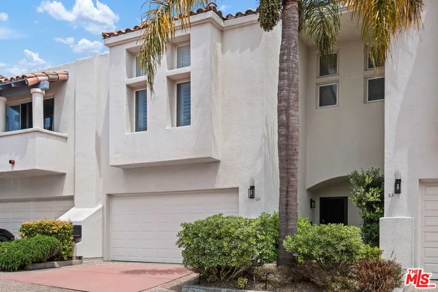 a front view of a house with a yard and potted plants
