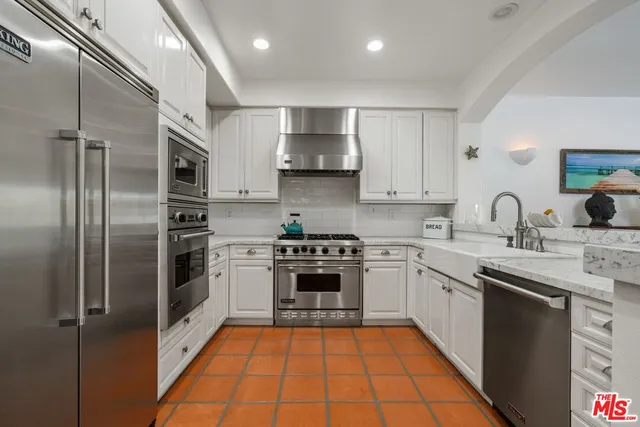 a kitchen with stainless steel appliances granite countertop a stove a sink and a refrigerator
