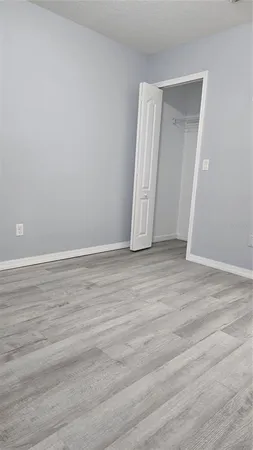 an empty room with wooden floor and closet