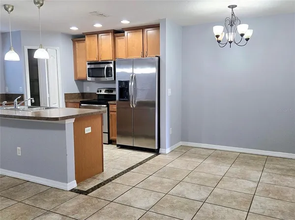 a kitchen with stainless steel appliances granite countertop a refrigerator and a sink