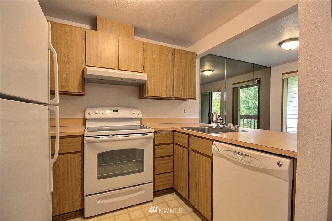 17419 119th Lane Southeast, Unit E31 Renton, WA 98058 - Photo 2 of 18 a kitchen with a stove sink and refrigerator