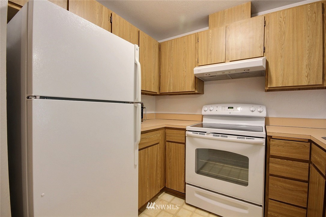 17419 119th Lane Southeast, Unit E31 Renton, WA 98058 - Photo 3 of 18 a white refrigerator freezer and a stove sitting inside of a kitchen