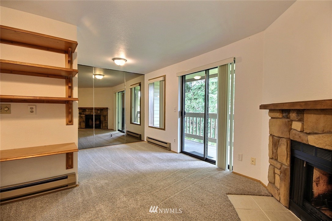 17419 119th Lane Southeast, Unit E31 Renton, WA 98058 - Photo 5 of 18 a view of an empty room with a fireplace and a window