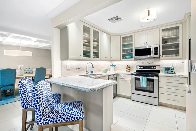 a kitchen with kitchen island granite countertop a sink cabinets and stainless steel appliances