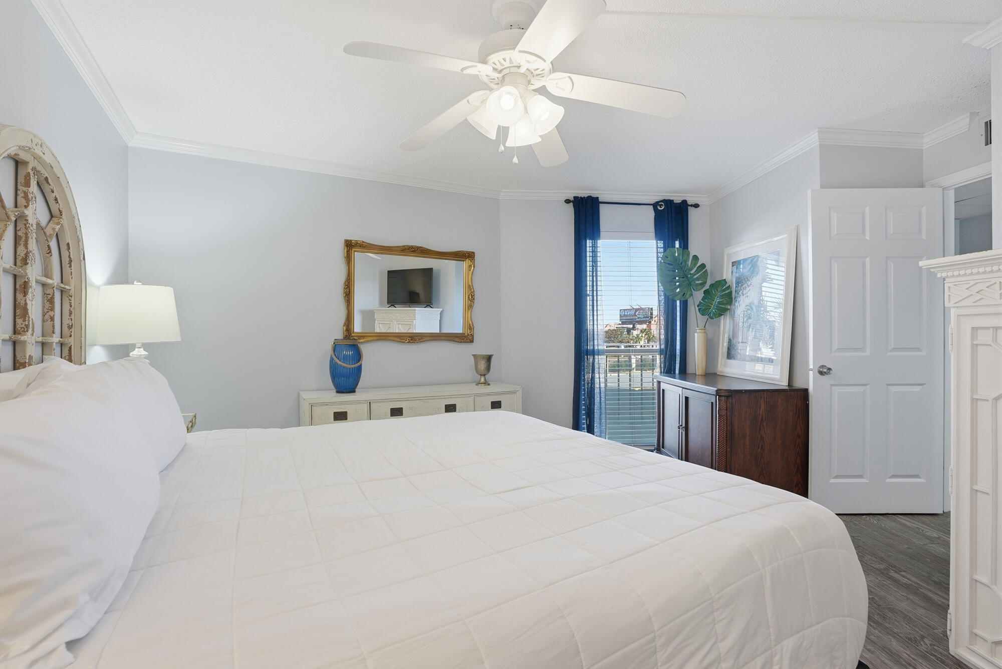 11483 Front Beach Road, Unit 105 Panama City Beach, FL 32407 - Photo 12 of 41 a bedroom with a large bed and a chandelier