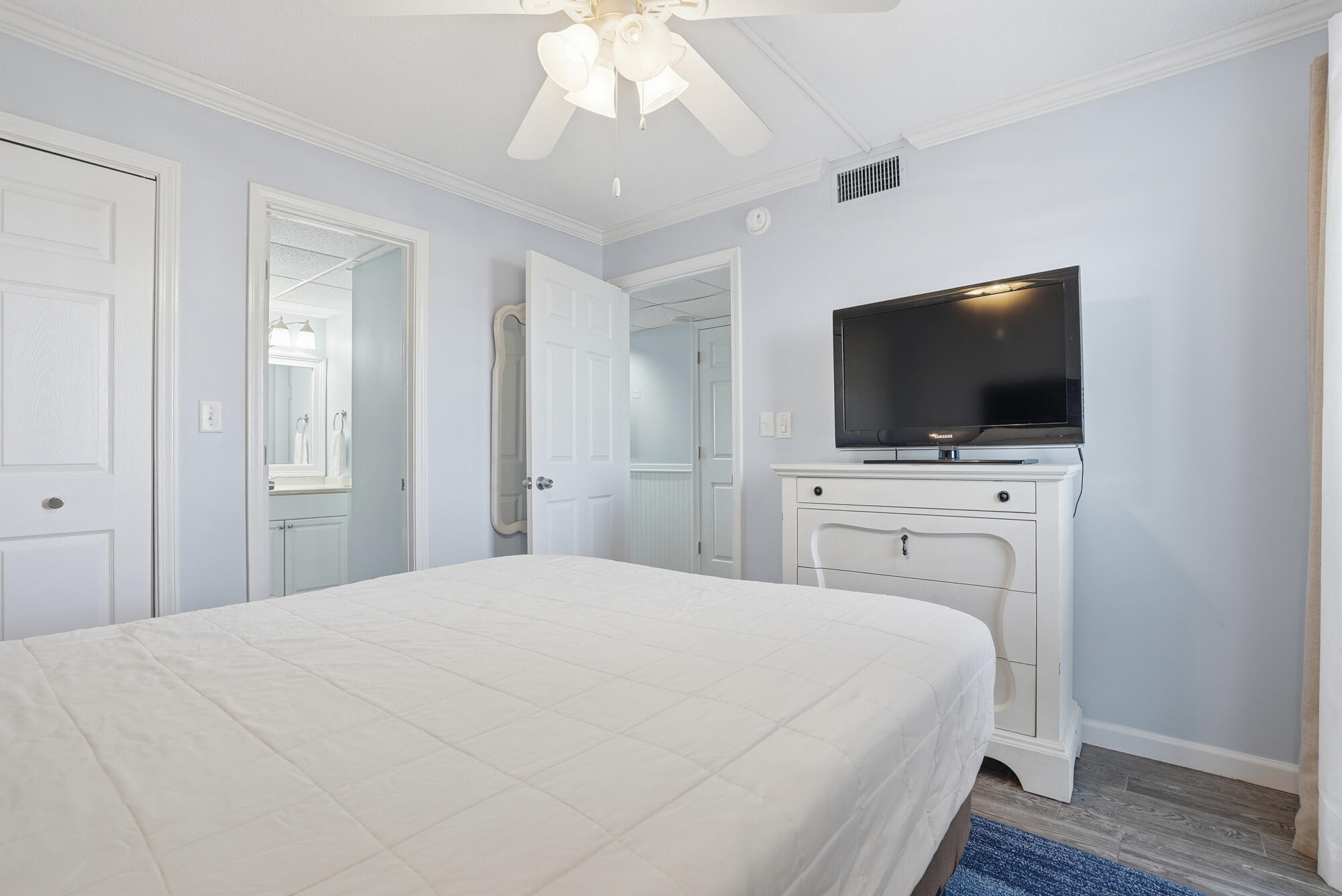 11483 Front Beach Road, Unit 105 Panama City Beach, FL 32407 - Photo 17 of 41 a bedroom with a bed and a flat tv screen on dresser