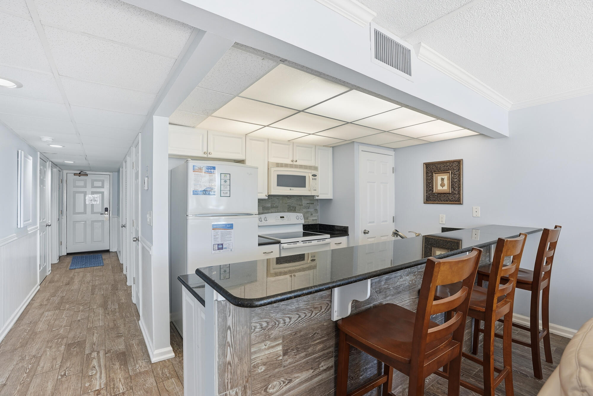 11483 Front Beach Road, Unit 105 Panama City Beach, FL 32407 - Photo 7 of 41 a kitchen that has a sink a table and chairs in it
