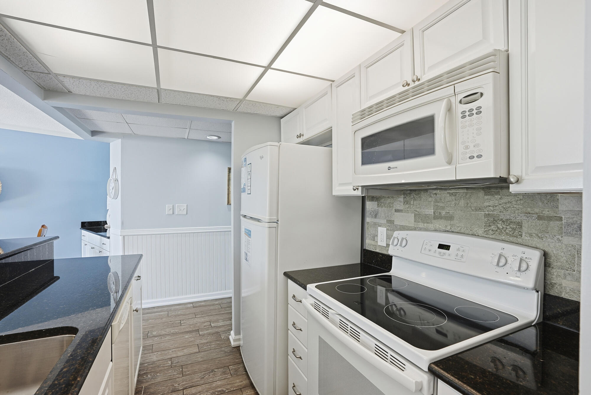 11483 Front Beach Road, Unit 105 Panama City Beach, FL 32407 - Photo 8 of 41 a kitchen with stainless steel appliances granite countertop a sink and microwave