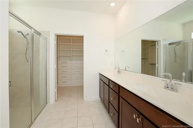 a bathroom with a double vanity sink a mirror and a shower