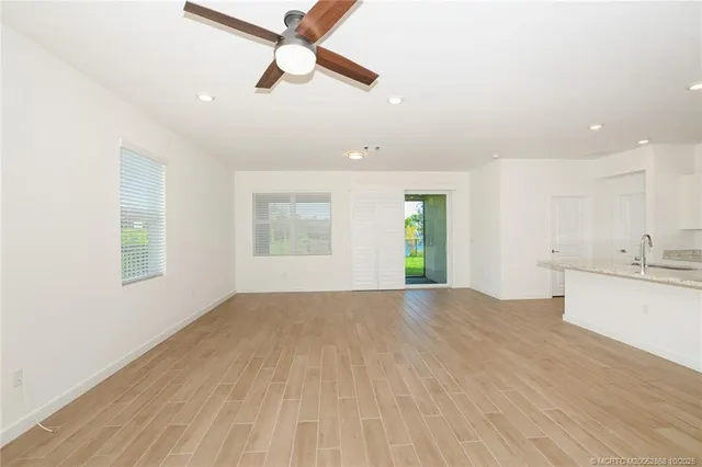 a view of an empty room with window and wooden floor