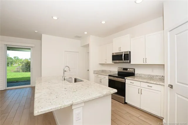 a kitchen with granite countertop white cabinets and white appliances