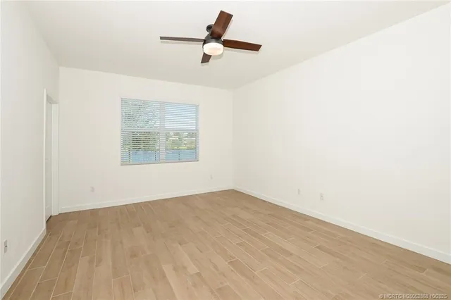 an empty room with a window and a ceiling fan
