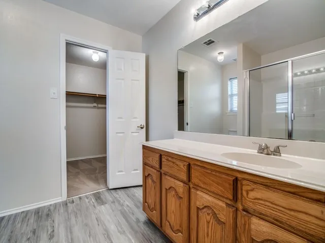 a spacious bathroom with a shower sink and mirror