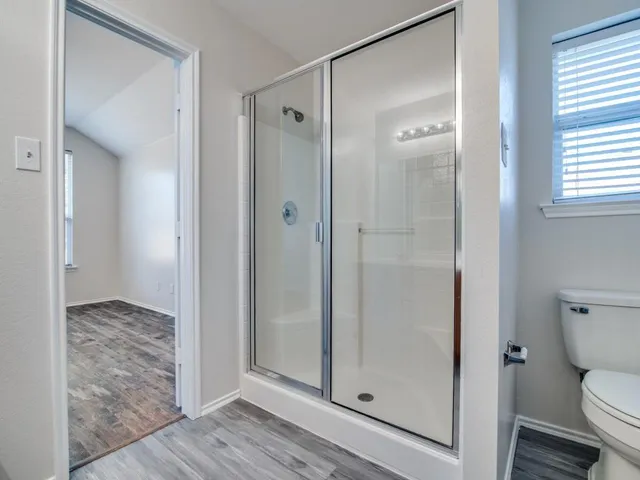 a bathroom with a granite countertop toilet a sink and shower