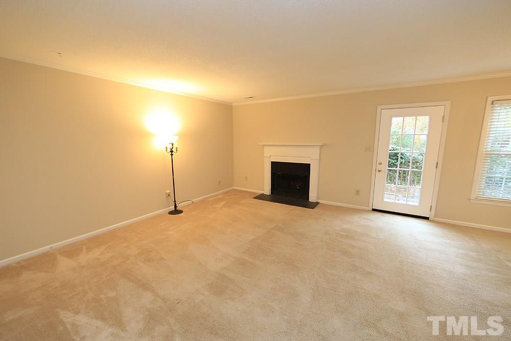 202 Bracken Court Raleigh, NC 27615 - Photo 8 of 19 Spacious Living Room with wood-burning fireplace and new exterior door to private deck.