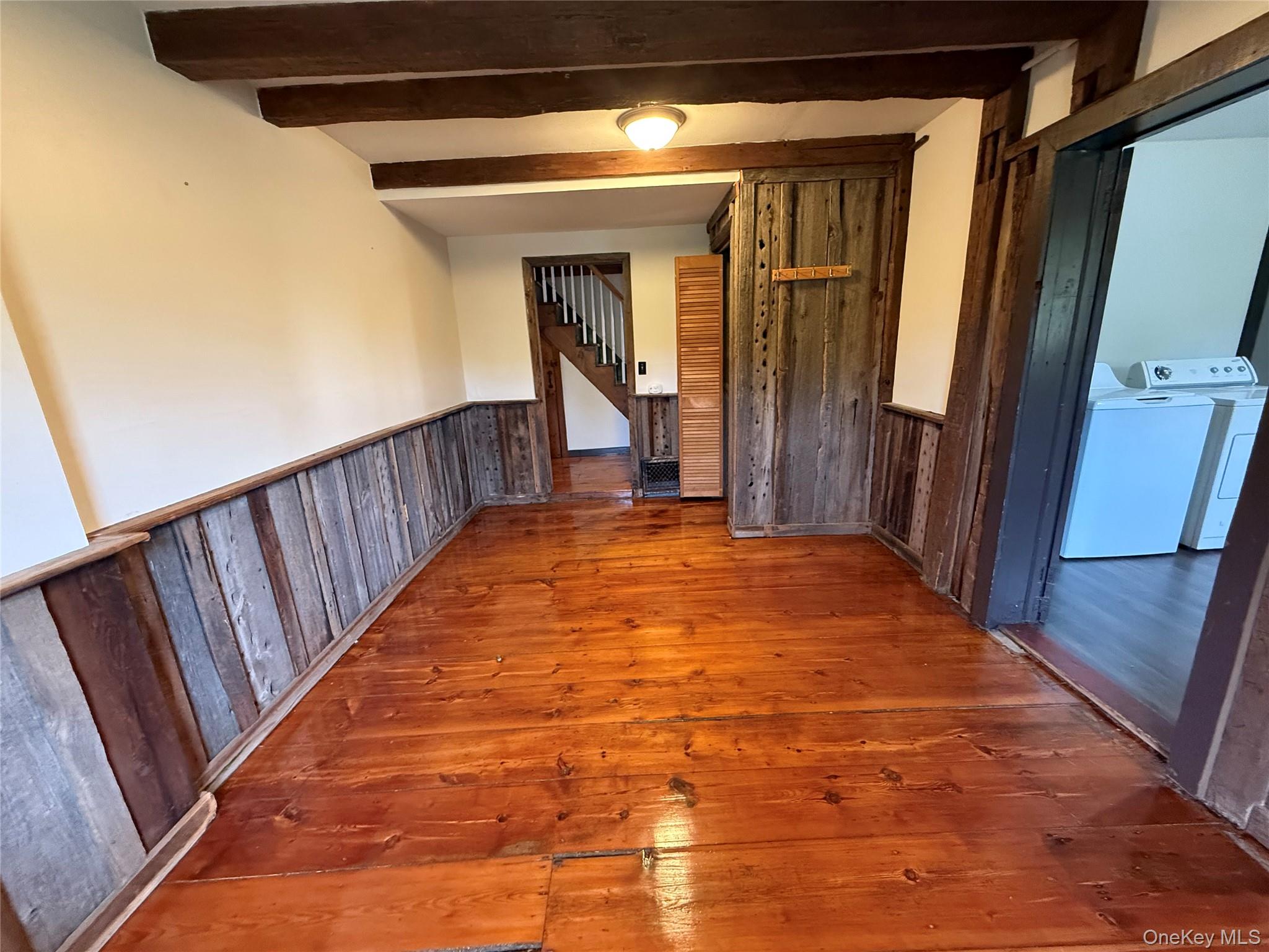 241 White Bridge Road Middletown, NY 10940 - Photo 9 of 29 Hall with wood-type flooring, a wainscoted wall, beamed ceiling, wooden walls, and stairway