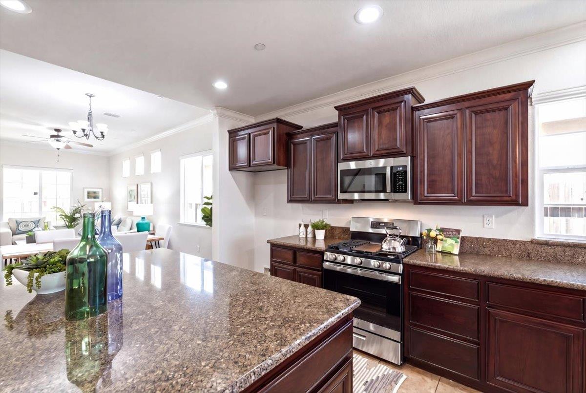 2036 Vignolia Loop Roseville, CA 95747 - Photo 11 of 27 a kitchen with stainless steel appliances granite countertop a stove top oven a sink dishwasher and cabinets with wooden floor