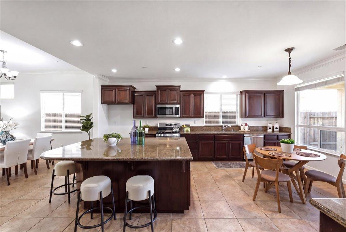2036 Vignolia Loop Roseville, CA 95747 - Photo 8 of 27 a large kitchen with a table and chairs