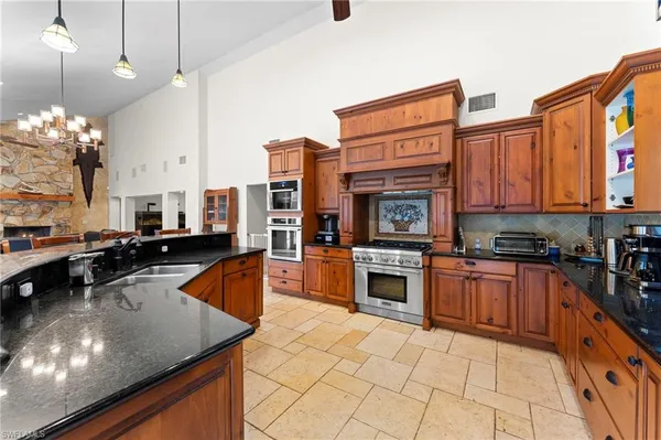 a kitchen with stainless steel appliances granite countertop a stove sink and cabinets