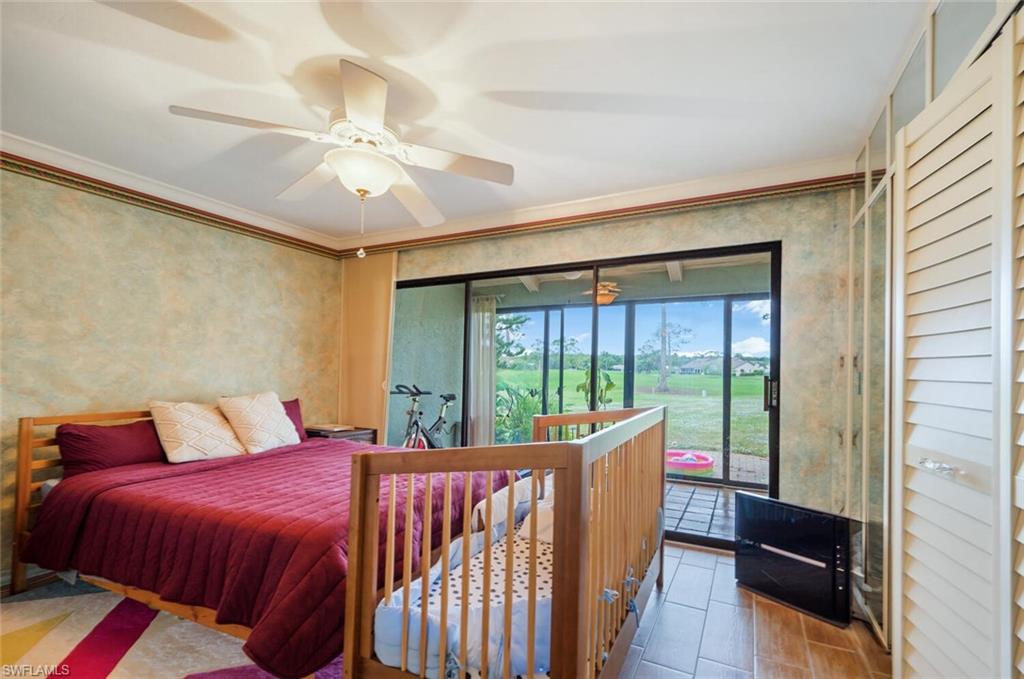 646 Augusta Boulevard Naples, FL 34113 - Photo 11 of 23 a bedroom with a bed and a large window with balcony view