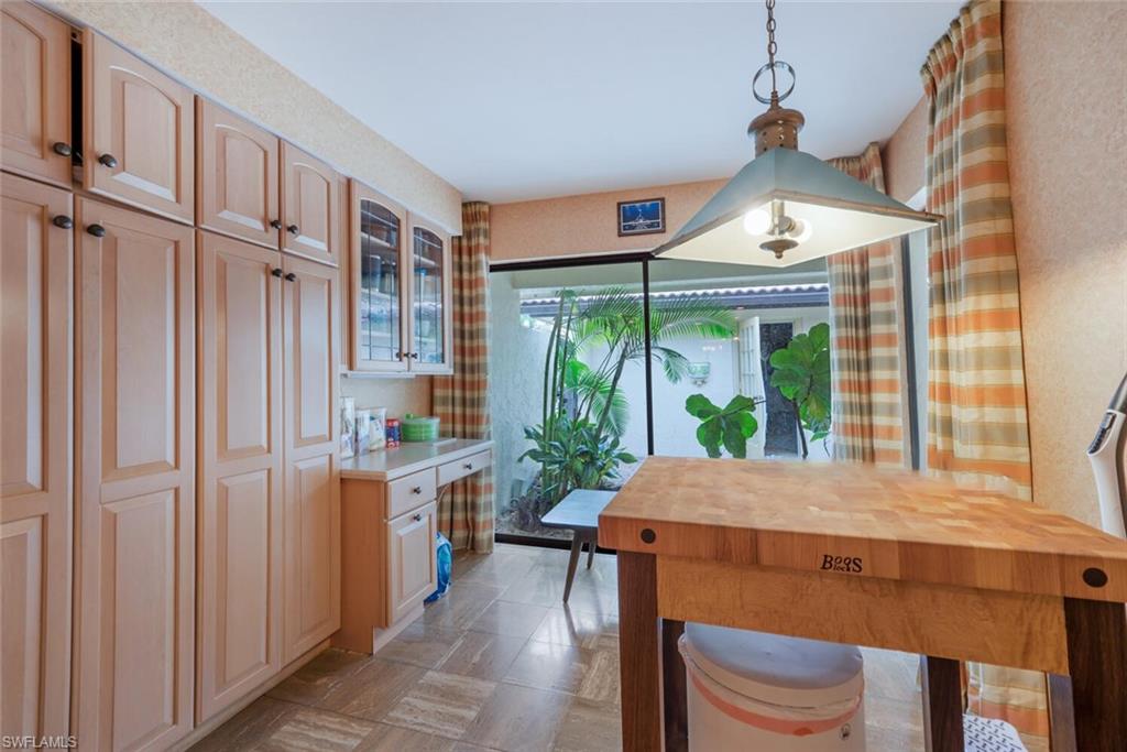 646 Augusta Boulevard Naples, FL 34113 - Photo 5 of 23 a kitchen with stainless steel appliances a table and chairs in it