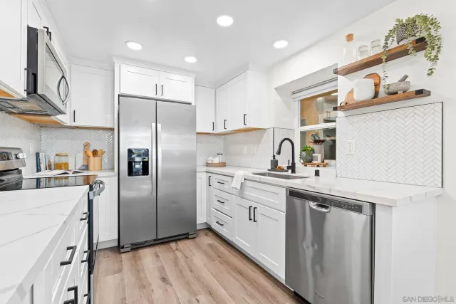 a kitchen with a refrigerator sink and cabinets