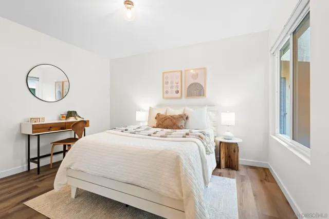 a bedroom with a bed a table and a potted plant