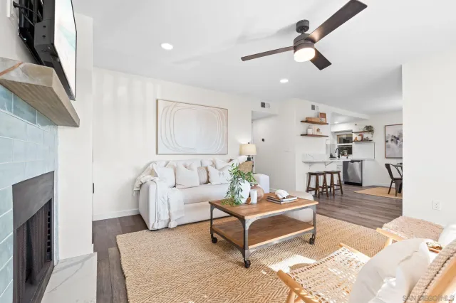 a living room with furniture and a ceiling fan