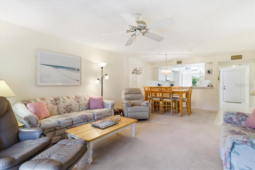 6713 Stone River Road, Unit 103 Bradenton, FL 34203 - Photo 3 of 86 a living room with furniture and a chandelier