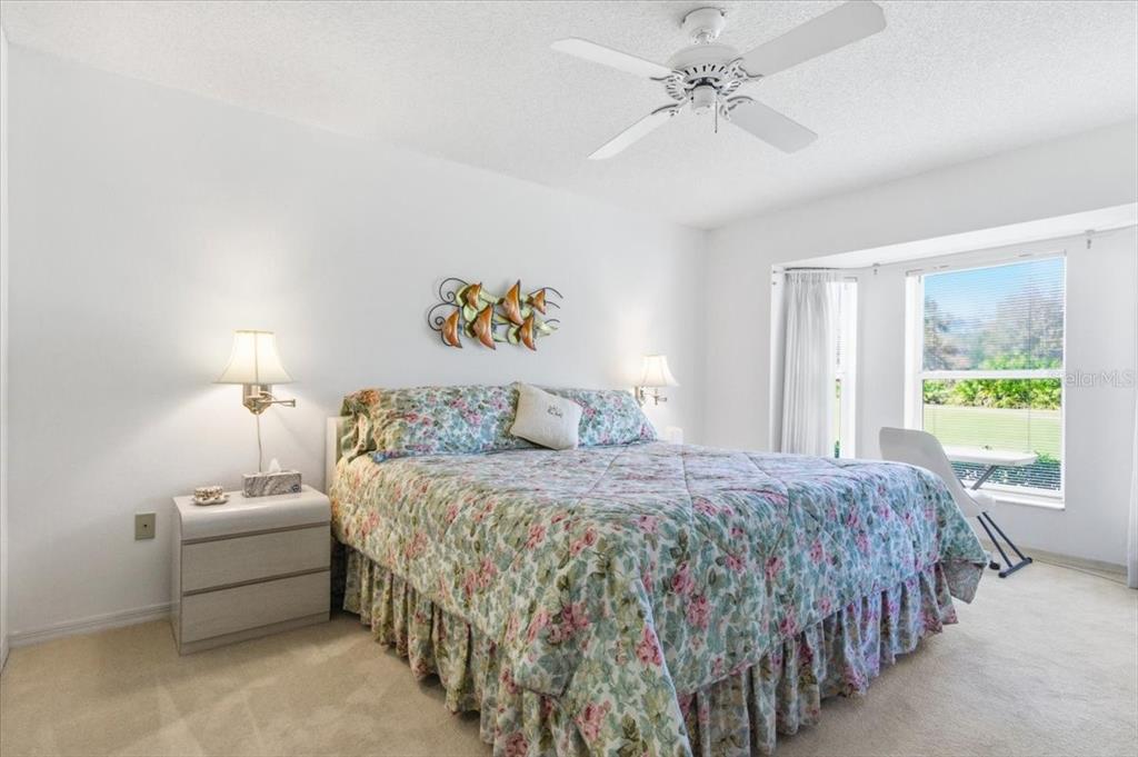 6713 Stone River Road, Unit 103 Bradenton, FL 34203 - Photo 5 of 86 a bedroom with a bed and a chandelier
