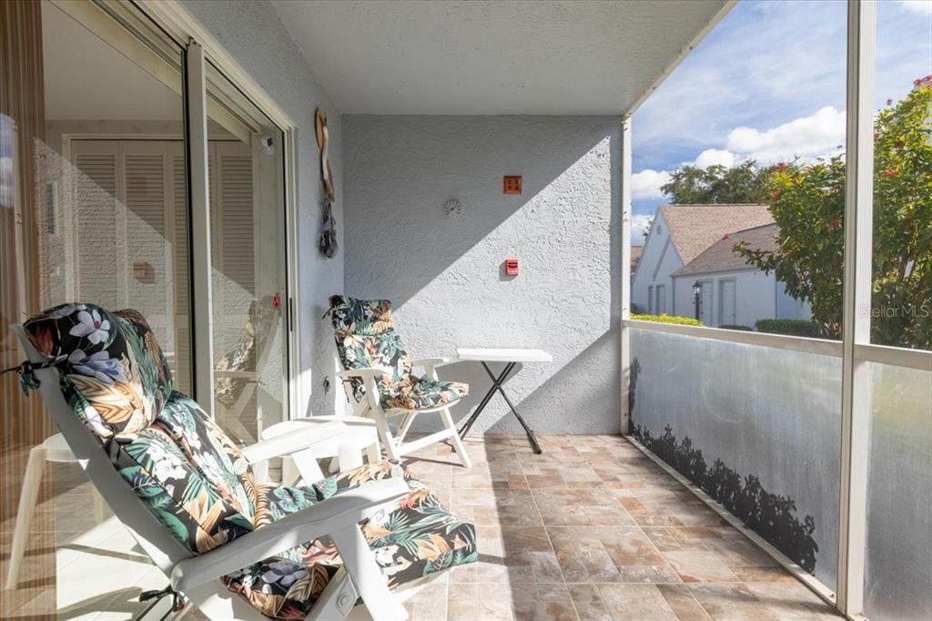 6713 Stone River Road, Unit 103 Bradenton, FL 34203 - Photo 8 of 86 a view of a balcony with chairs and floor to ceiling window