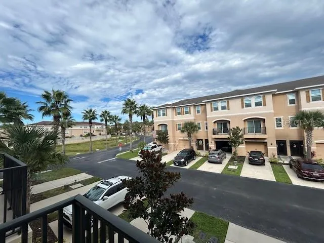 a view of a patio with table and chairs potted plants with floor to ceiling window yard and mountain view in back