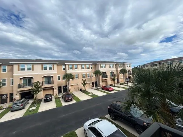 a view of a patio with lawn chairs and floor to ceiling window