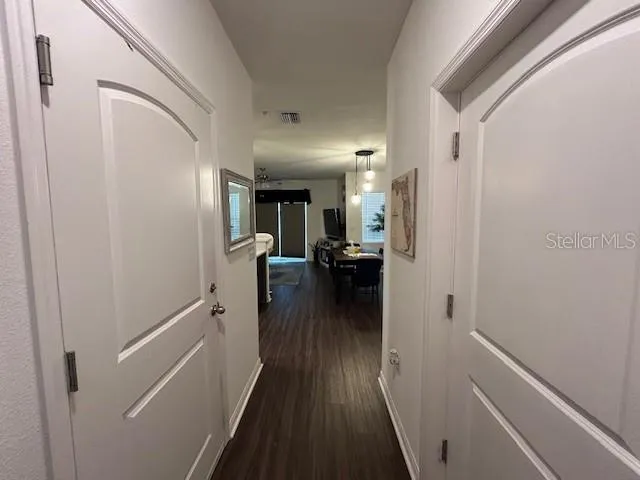 a view of a hallway view with wooden floor and living room
