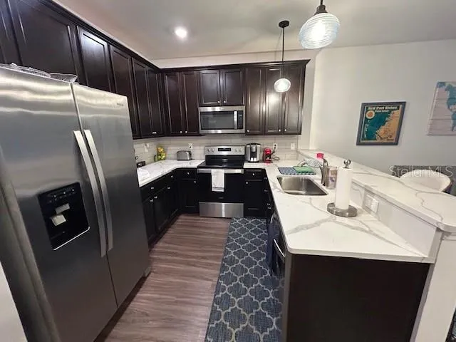 a kitchen with stainless steel appliances granite countertop a sink refrigerator and cabinets