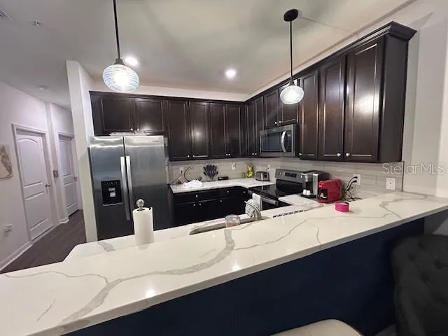 a kitchen with stainless steel appliances a sink stove and refrigerator