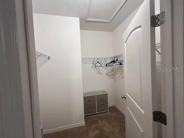 a view of walk in closet with clothes
