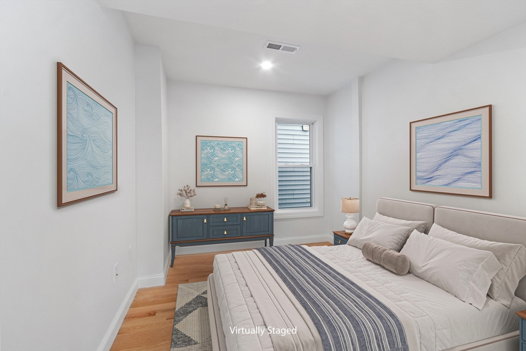 55 Mansfield Street, Unit A Gloucester, MA 01930 - Photo 8 of 18 a bedroom with a bed and a painting on the wall
