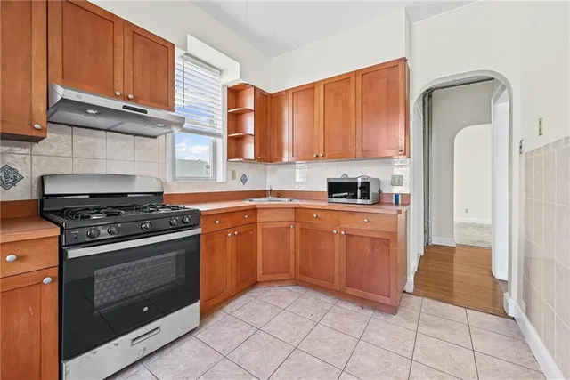 a kitchen with a stove sink and cabinets