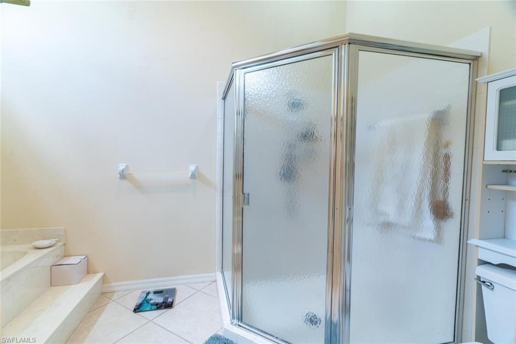 458 Countryside Drive Naples, FL 34104 - Photo 23 of 50 Bathroom featuring light tile patterned floors, a shower stall, and a garden tub