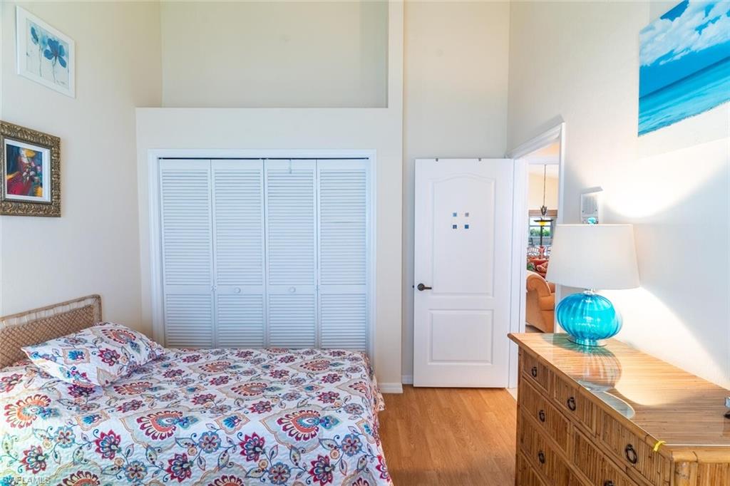 458 Countryside Drive Naples, FL 34104 - Photo 29 of 50 Bedroom with light wood-style flooring and a towering ceiling