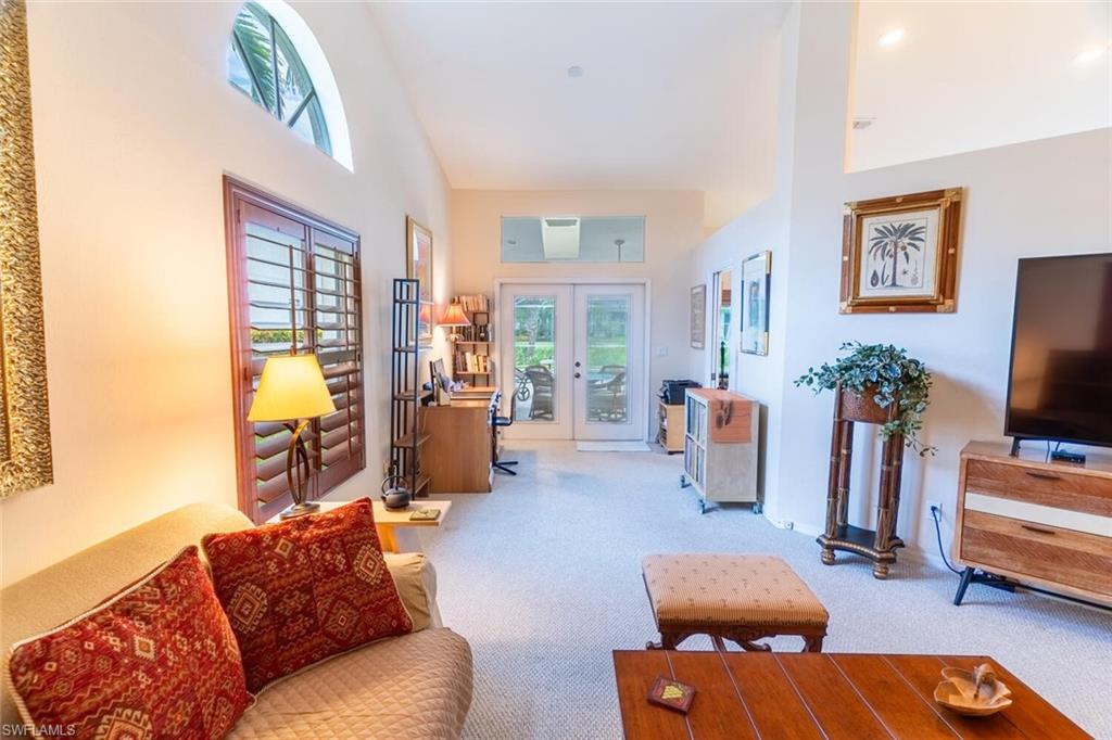 458 Countryside Drive Naples, FL 34104 - Photo 31 of 50 Carpeted living room featuring french doors and a high ceiling
