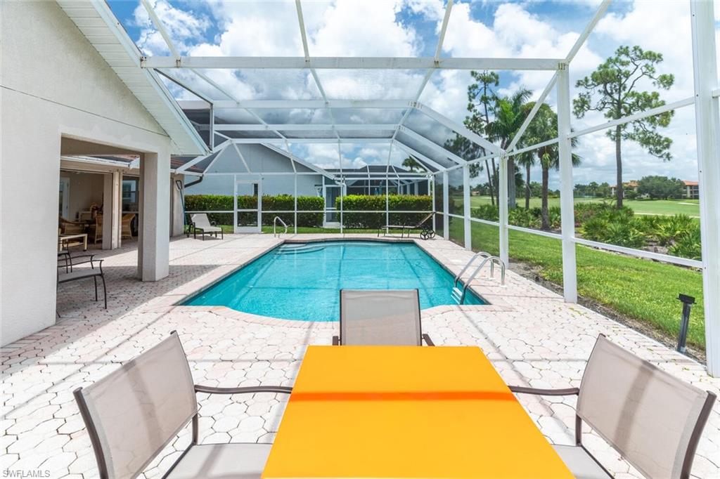 458 Countryside Drive Naples, FL 34104 - Photo 42 of 50 Outdoor pool with a patio, a sunroom, glass enclosure, and a yard