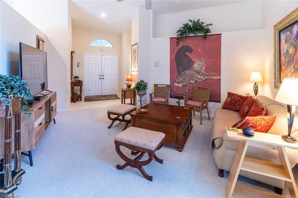458 Countryside Drive Naples, FL 34104 - Photo 8 of 50 Living room with a high ceiling, light carpet, and ceiling fan