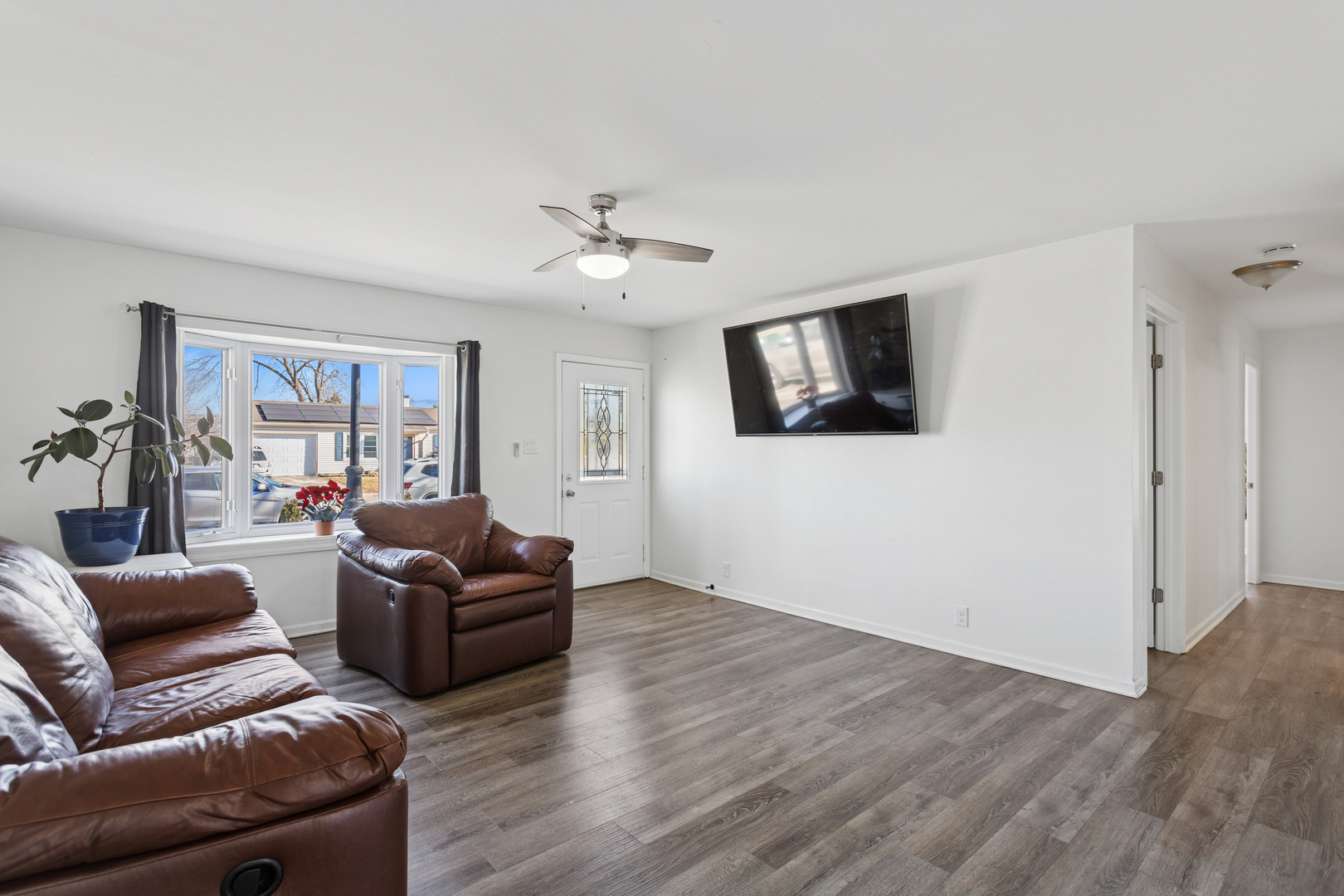 516 Dalhart Avenue Romeoville, IL 60446 - Photo 2 of 19 a living room with furniture a flat screen tv and a ceiling fan