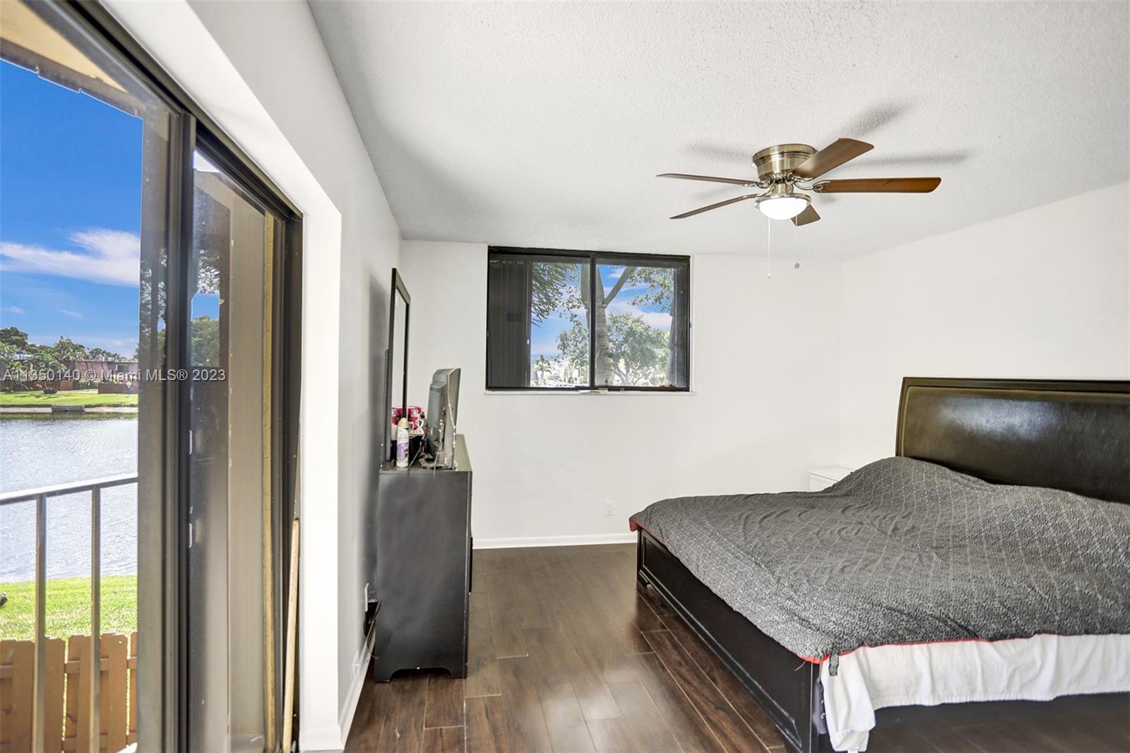 84 Springdale Circle Palm Springs, FL 33461 - Photo 20 of 32 a bedroom with a bed and wooden floor