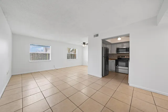 a view of an empty room with window and cabinet