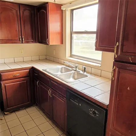 a kitchen with a sink cabinets appliances and a window