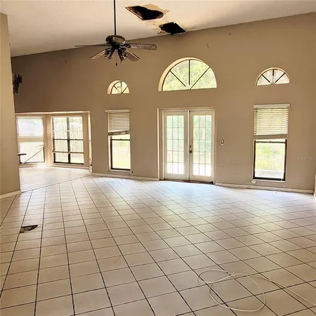 an empty room with fan and windows