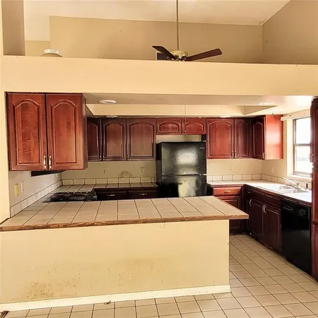 a kitchen with kitchen island granite countertop a sink and a stove